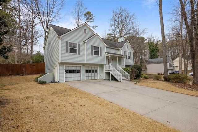 bi-level home with a garage and a front lawn