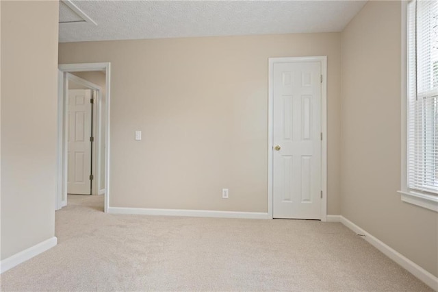 unfurnished bedroom featuring light carpet and a textured ceiling