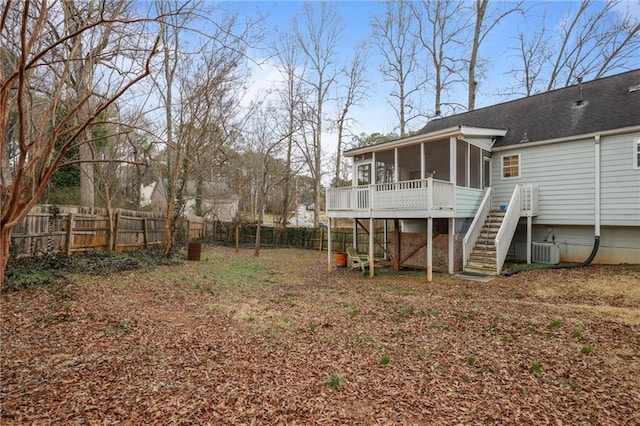 view of yard with central AC, a sunroom, and a deck