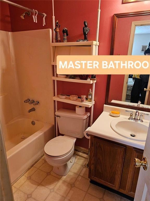 full bathroom with bathtub / shower combination, vanity, and toilet