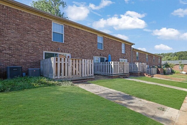 back of house with a yard and central AC unit