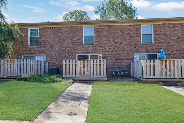 rear view of property with cooling unit, a wooden deck, and a yard