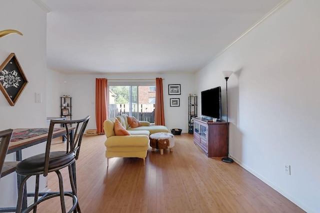 living room with crown molding and light hardwood / wood-style floors