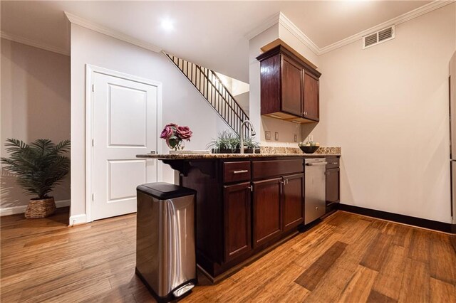 bar with sink, light hardwood / wood-style flooring, stainless steel dishwasher, dark brown cabinets, and ornamental molding