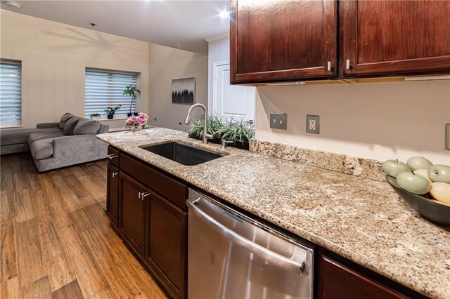 kitchen with light stone counters, sink, stainless steel dishwasher, and light wood-type flooring