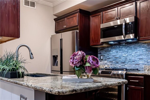 kitchen featuring sink, tasteful backsplash, light stone counters, crown molding, and appliances with stainless steel finishes