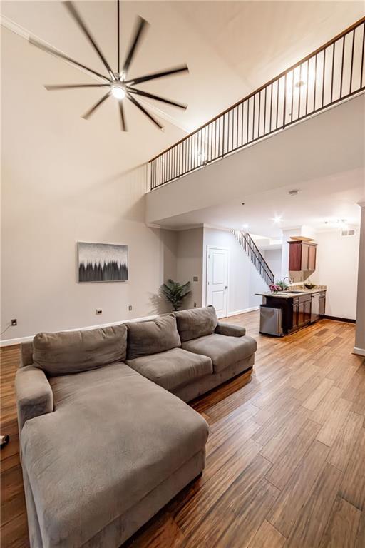 living room featuring a high ceiling, light hardwood / wood-style floors, and sink