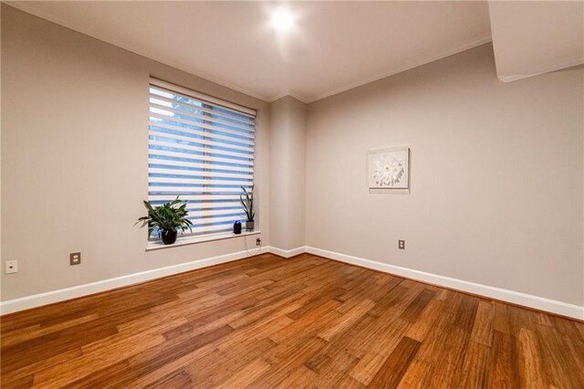 spare room with crown molding and hardwood / wood-style flooring