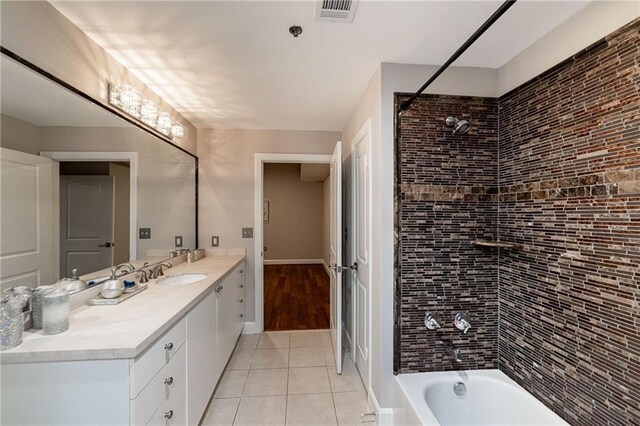 bathroom featuring tile patterned floors, tiled shower / bath combo, and vanity