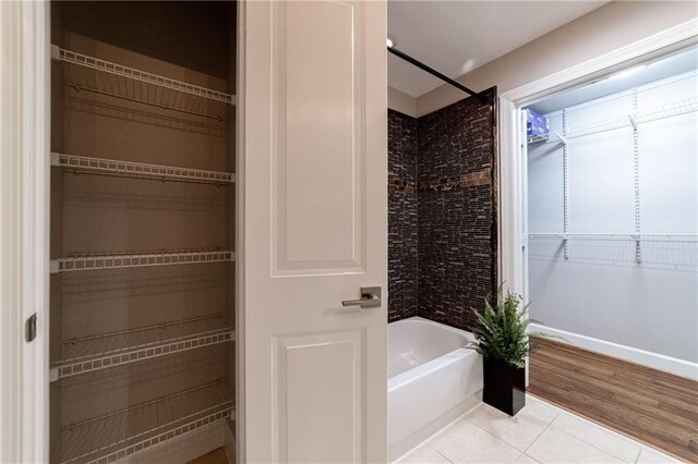 bathroom featuring hardwood / wood-style flooring and tiled shower / bath combo