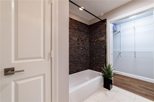 bathroom featuring tiled shower / bath combo and hardwood / wood-style flooring