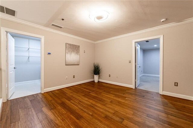 empty room with dark hardwood / wood-style floors and ornamental molding