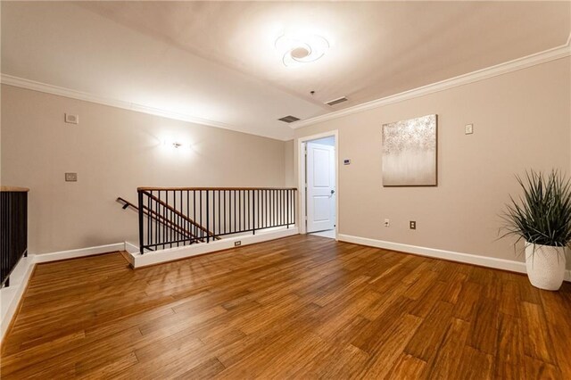 spare room with hardwood / wood-style floors and crown molding