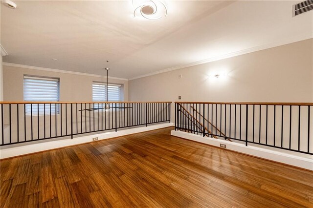 unfurnished room featuring hardwood / wood-style flooring and ornamental molding