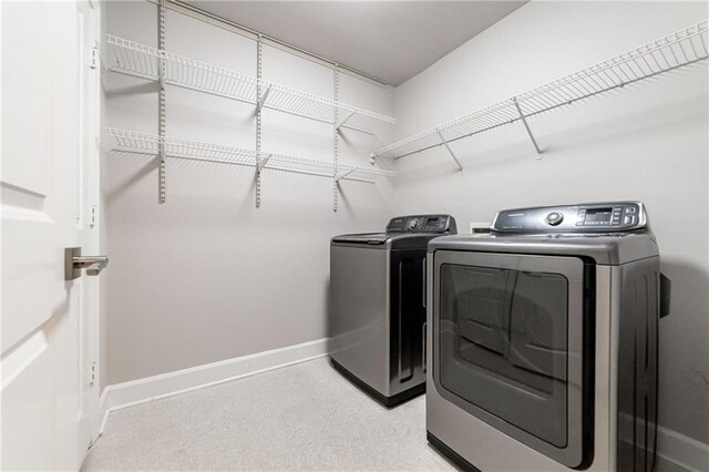 clothes washing area featuring light carpet and washing machine and dryer