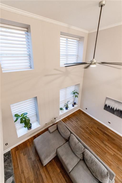 living room featuring hardwood / wood-style floors, a healthy amount of sunlight, and ornamental molding