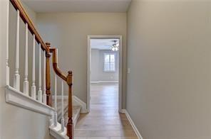1668 Sabastian Pt NE, Atlanta, GA 30329 - hallway featuring stairs, baseboards, and wood finished floors