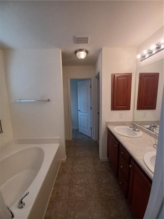 bathroom featuring vanity, a tub to relax in, and tile patterned floors