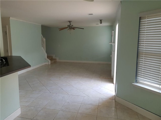 unfurnished living room featuring ceiling fan and light tile patterned flooring