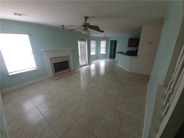 unfurnished living room with ceiling fan and light tile patterned floors