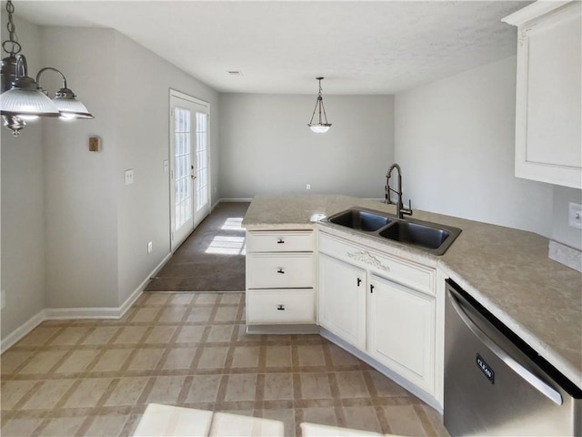 kitchen featuring white cabinetry, a sink, decorative light fixtures, and dishwashing machine