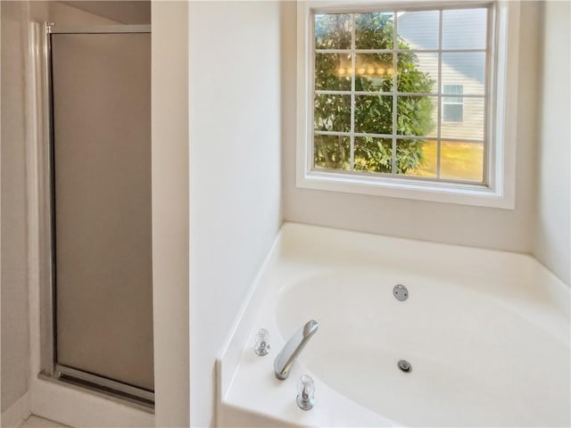 full bathroom featuring a stall shower and a garden tub