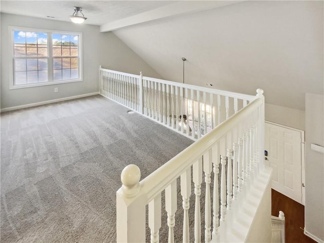 interior space featuring carpet floors, lofted ceiling with beams, and baseboards