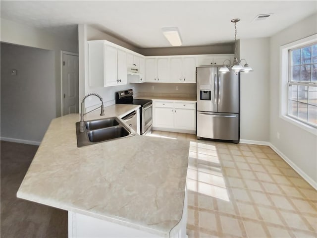 kitchen featuring baseboards, visible vents, appliances with stainless steel finishes, light countertops, and a sink