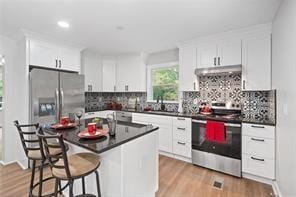 440 Colbert Rd, Dallas, GA 30132 - kitchen with appliances with stainless steel finishes, light wood-type flooring, dark countertops, tasteful backsplash, and recessed lighting