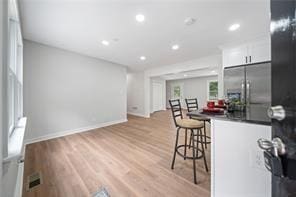 440 Colbert Rd, Dallas, GA 30132 - kitchen featuring stainless steel refrigerator with ice dispenser, a kitchen breakfast bar, light wood-style floors, dark countertops, and recessed lighting