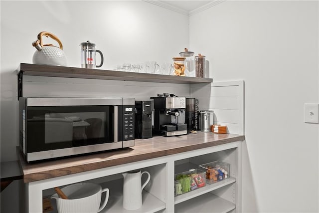 bar with stainless steel microwave and crown molding