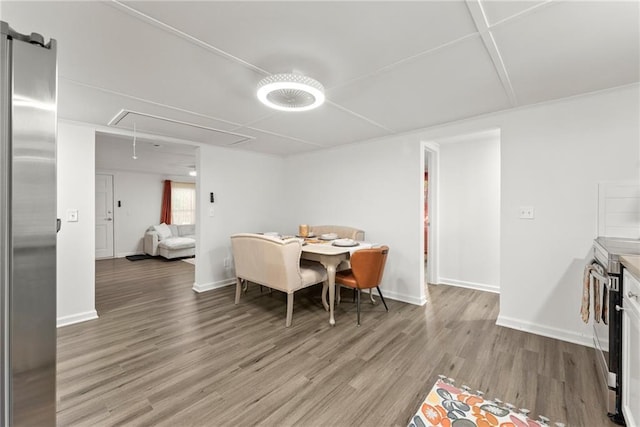 dining room with wood finished floors, attic access, and baseboards