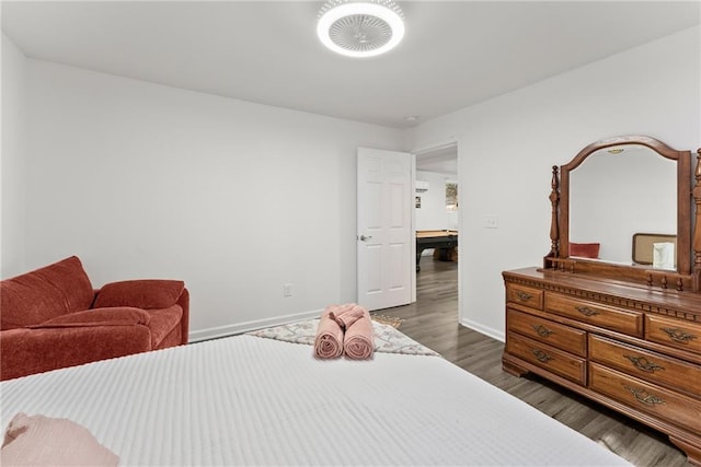 bedroom featuring baseboards and dark wood-style flooring