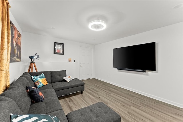 living area with baseboards and wood finished floors