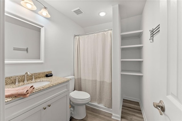 bathroom with visible vents, toilet, wood finished floors, curtained shower, and vanity