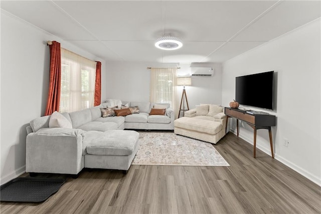 living area featuring a wall mounted air conditioner, baseboards, and wood finished floors