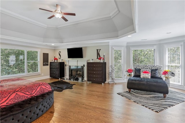 bedroom featuring access to outside, crown molding, ceiling fan, a premium fireplace, and wood-type flooring