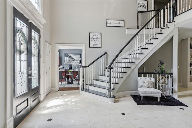 tiled entryway featuring a high ceiling and french doors