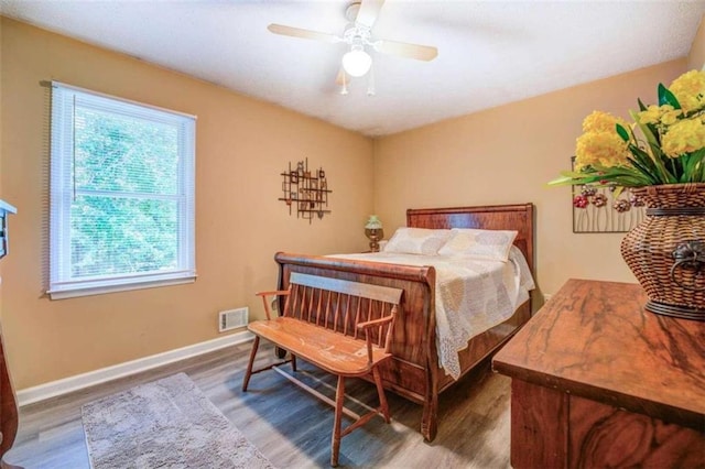 bedroom featuring multiple windows, ceiling fan, and hardwood / wood-style floors