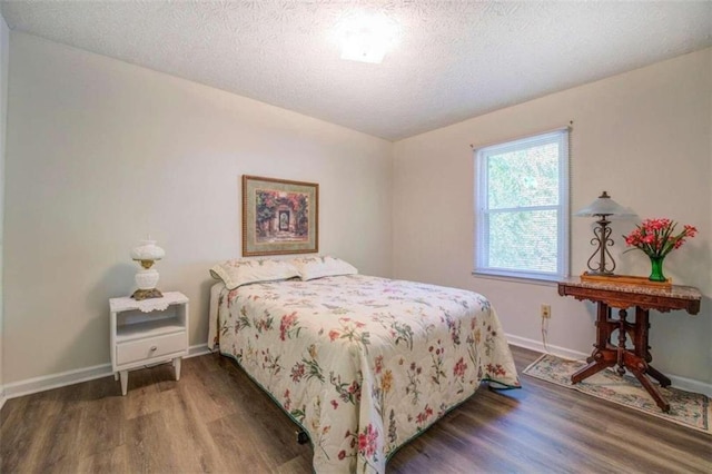 bedroom featuring a textured ceiling and dark hardwood / wood-style floors