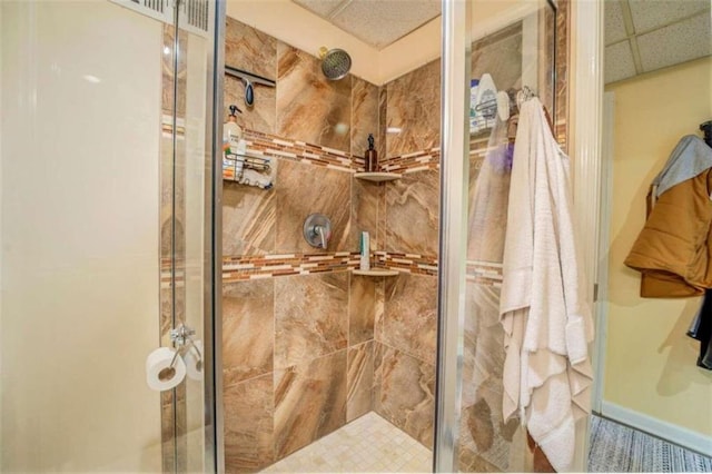 bathroom featuring an enclosed shower and a drop ceiling