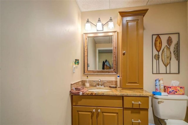 bathroom featuring a textured ceiling, vanity, and toilet