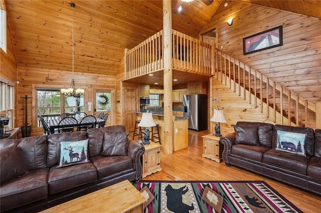 living room with wooden walls, light hardwood / wood-style flooring, high vaulted ceiling, and wooden ceiling