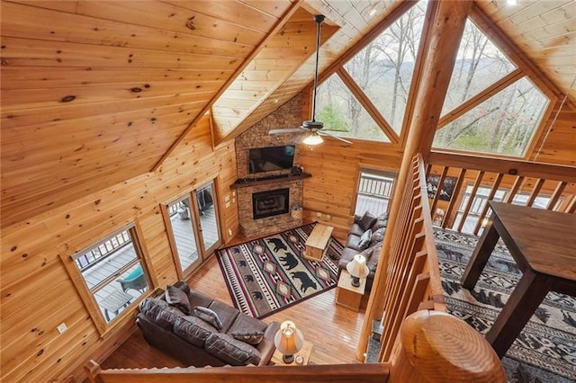 living room with wood walls, hardwood / wood-style floors, and high vaulted ceiling