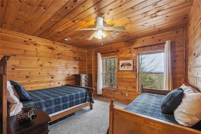 carpeted bedroom featuring ceiling fan, wood walls, and wooden ceiling