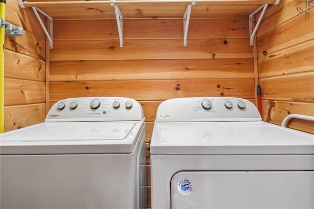 laundry room with wood walls and independent washer and dryer