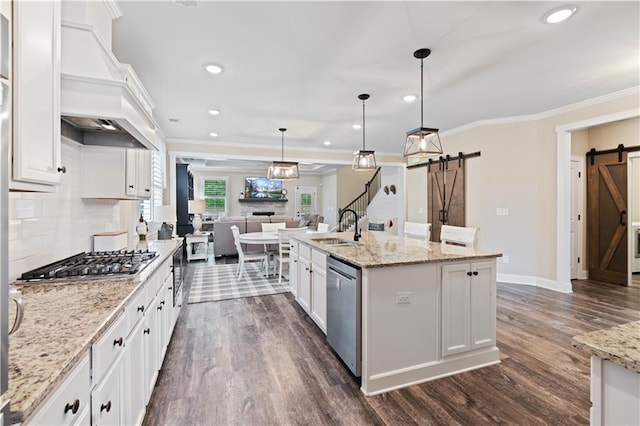 3392 Fall Branch Ln, Buford, GA 30519 - kitchen with a barn door, stainless steel appliances, dark wood-style flooring, custom range hood, and white cabinets