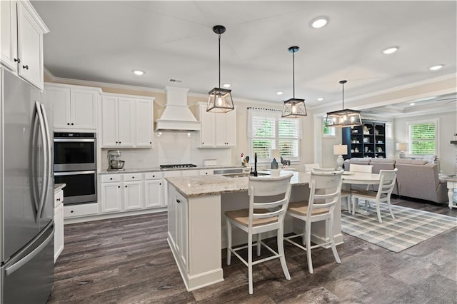 3392 Fall Branch Ln, Buford, GA 30519 - kitchen with appliances with stainless steel finishes, custom range hood, crown molding, healthy amount of natural light, and white cabinetry
