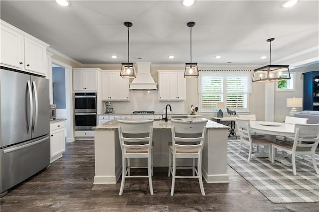 3392 Fall Branch Ln, Buford, GA 30519 - kitchen with appliances with stainless steel finishes, premium range hood, a center island with sink, white cabinetry, and recessed lighting