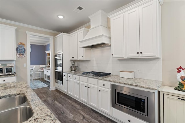3392 Fall Branch Ln, Buford, GA 30519 - kitchen with premium range hood, stainless steel appliances, dark wood finished floors, white cabinets, and decorative backsplash